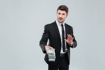 Attractive businessman in suit and tie giving you money back