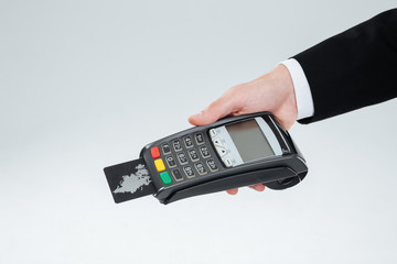 Hand of businessman holding bank terminal with credit card