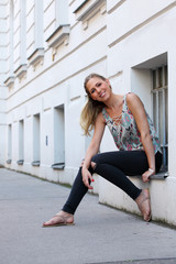 Beautiful blonde woman with jeans and sandals on the street