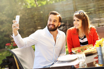 Young couple taking selfie in a restaurant