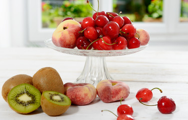 cherries, and peaches in a glass cup with kiwis