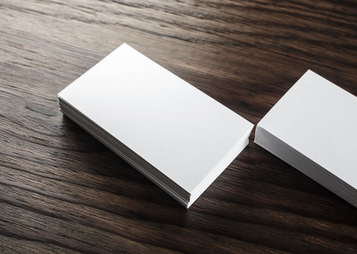 Blank business cards. Photo of blank white business cards on wooden background. Mock-up for design presentations and portfolios. Blank template for ID.