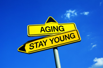 Aging or Stay Young - Traffic sign with two options - decision to stay attractive and fit and healthy with good physical condition despite of age and biological process of growing older
