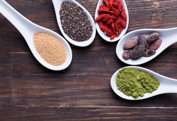 "Super foods" in the spoons on the wooden background