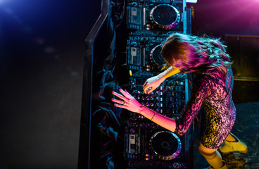 Disc jockey girl mixing electronic music in club