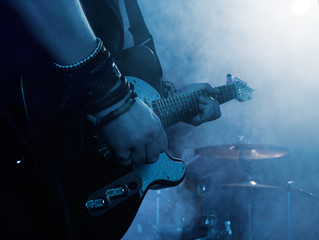 Silhouette of guitar player on stage.