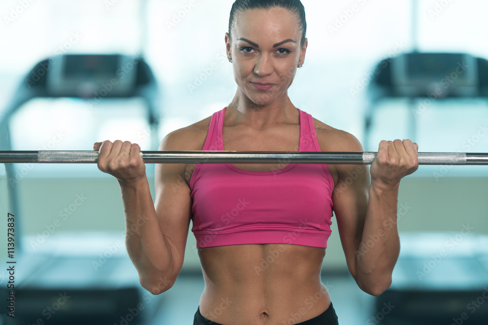 Wall mural Fitness Woman Doing Exercise For Biceps With Barbell