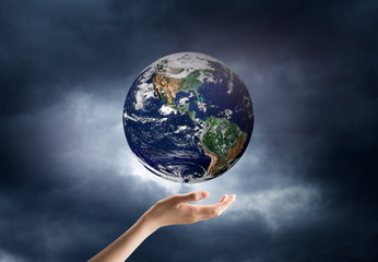 hand holding a planet in space. Elements of this image are furni