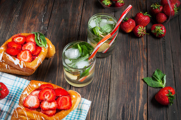Refreshing summer drink with mint inglasses and strawberry on the vintage wooden table