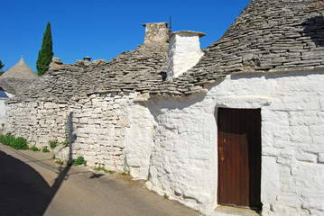 Fototapeta na wymiar An alley between the characteristic trulli of Alberobello in Apu