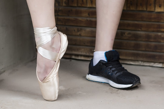 Feet dressed in dance pointe shoes and sports shoes