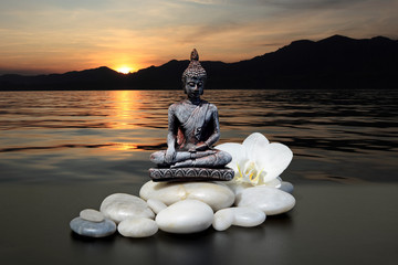 Fond Zen ou Feng-Shui-Bouddha, pierre zen, fleurs d& 39 orchidées blanches. En arrière-plan, le soleil se couche derrière les montagnes