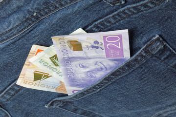 Swedish bank notes sticking up from a jeans pocket