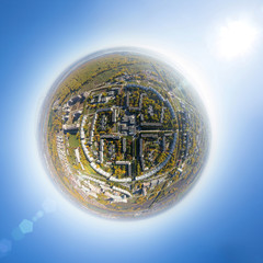 Aerial city view with crossroads and roads, houses, buildings, parks and parking lots, bridges. Copter shot. Little planet mode.