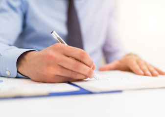 Businessman writing in a document