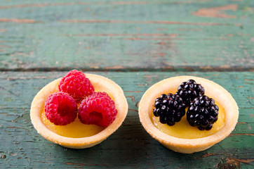 Homemade round tartlets with lemon curd, fresh blackberries and raspberries