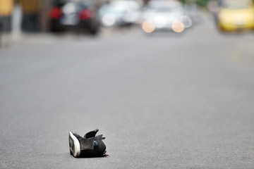 Shoe on the street with cars in background after accident