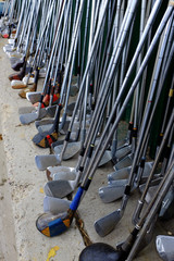 Row of Many Old Used Golf Clubs for Sport