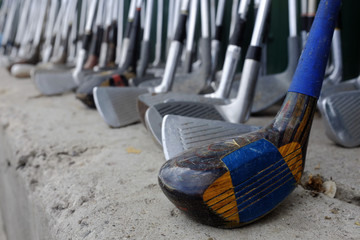 Row of Many Old Used Golf Clubs for Sport