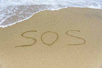 Word SOS on the beach.