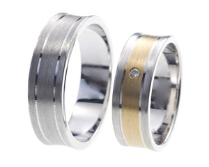 Two rings made of gold and white gold, one with diamond, isolated on white