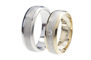 Two rings made of gold and white gold, one with diamond, isolated on white