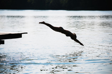 woman jumping into the lake