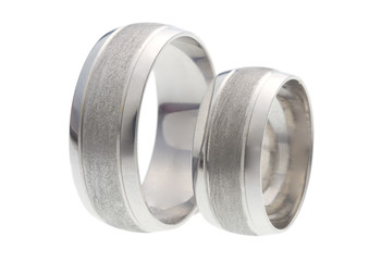Two wedding rings standing next to each other isolated on white