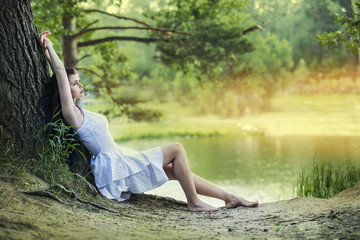 Young beautiful brunette woman sitting and resting in the woods