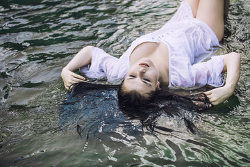 Young beautiful woman enjoys the lake with turquoise clear water
