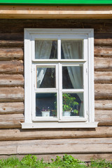Fototapeta na wymiar Window on old wooden facade of Russian town
