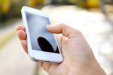 Woman holding smartphone outside