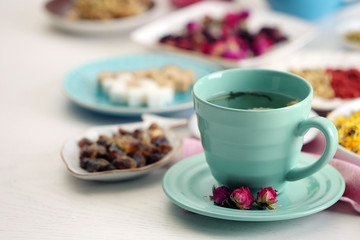 Cup of tea with aromatic dry tea on wooden background