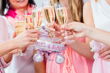 Friends clinking glasses on baby shower party