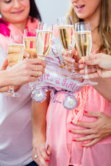 Friends clinking glasses on baby shower party