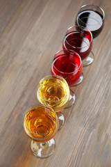 Glasses with wines of different colors on a wooden table