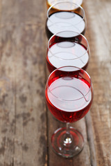 Glasses with wines of different colors on a wooden table