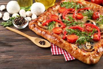 Freshly homemade pizza on wooden background