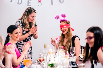 Cheerful bride and bridesmaids celebrating hen party with drinks