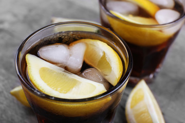 Glasses of soda water and sliced lemon on wooden table, close up