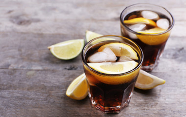 Glasses of soda water with sliced lemon on wooden table