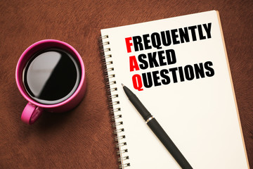FAQ Acronym - text on notebook with a pen and cup of coffee
