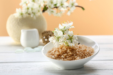 Spa treatment with blooming branch on white wooden table