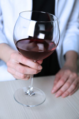 Woman holding glass of wine, closeup