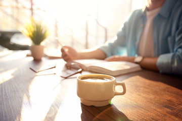 White cup of coffee and young man on background