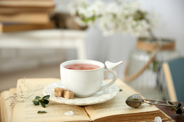 Open book and cup of tea wooden table