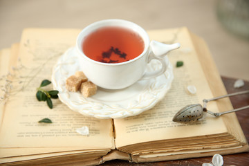 Open book and cup of tea wooden table