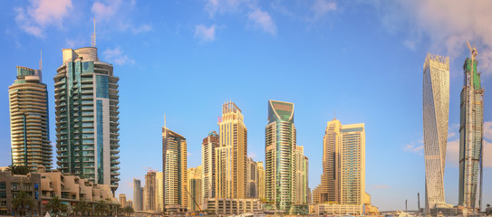 Panoramic view of Dubai Marina bay with yacht and cloudy sky, Dubai, UAE