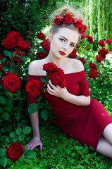 Lady vamp in crimson red dress with naked shoulders and red rose