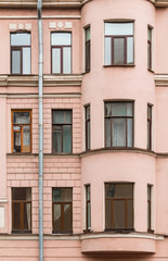 Several windows in a row and bay window on facade of urban apartment building front view, St. Petersburg, Russia.